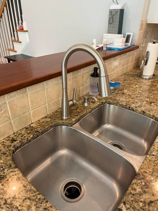 Double-basin stainless steel kitchen sink with a brushed metal faucet