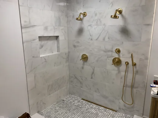Finished walk-in shower with brass fixtures