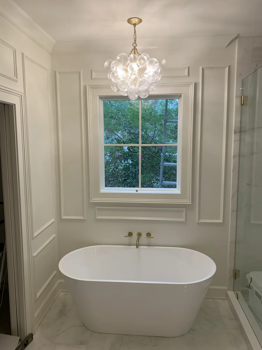 Freestanding bathtub installation beneath a window